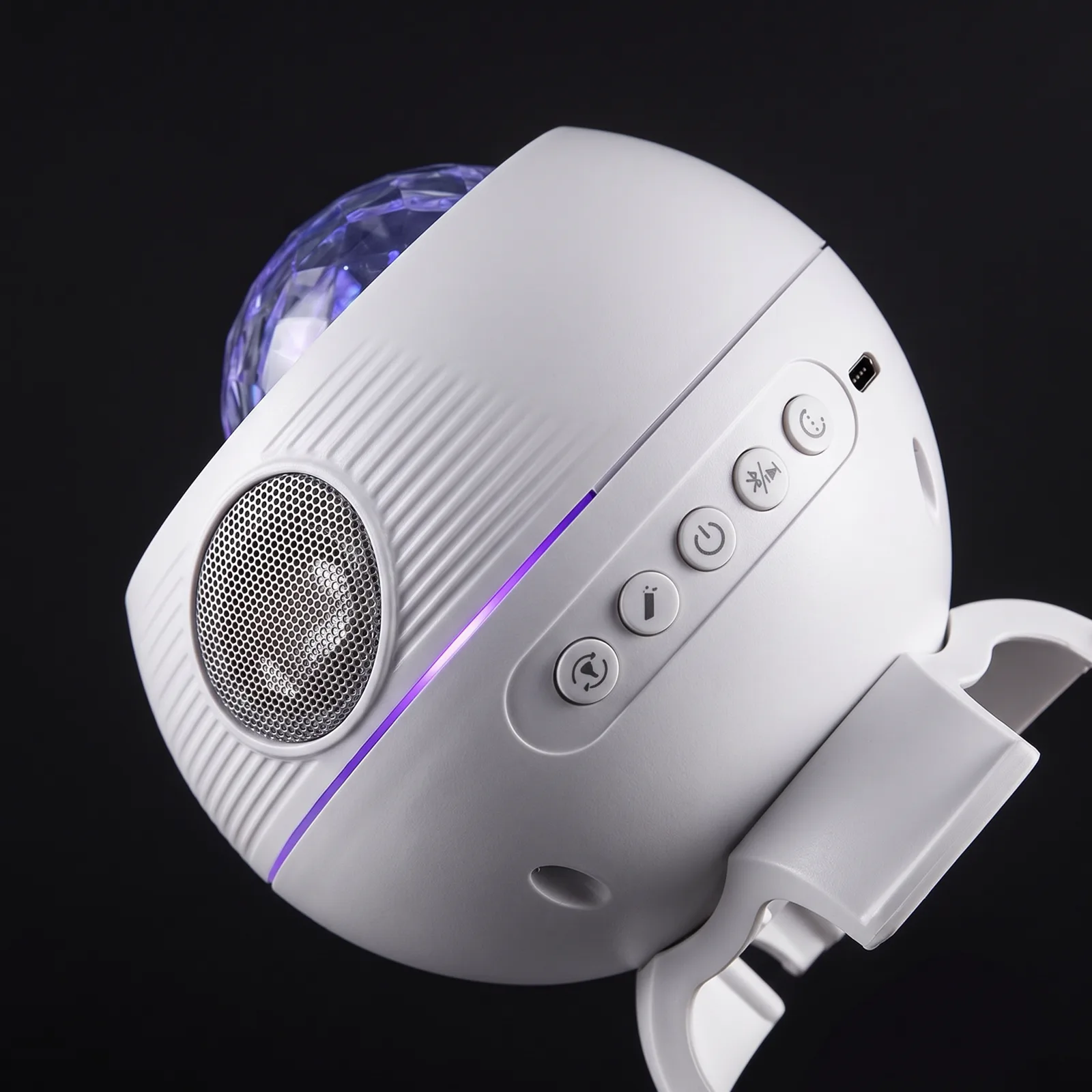 Detail of the built-in speaker grille and controls, violet light along the seam